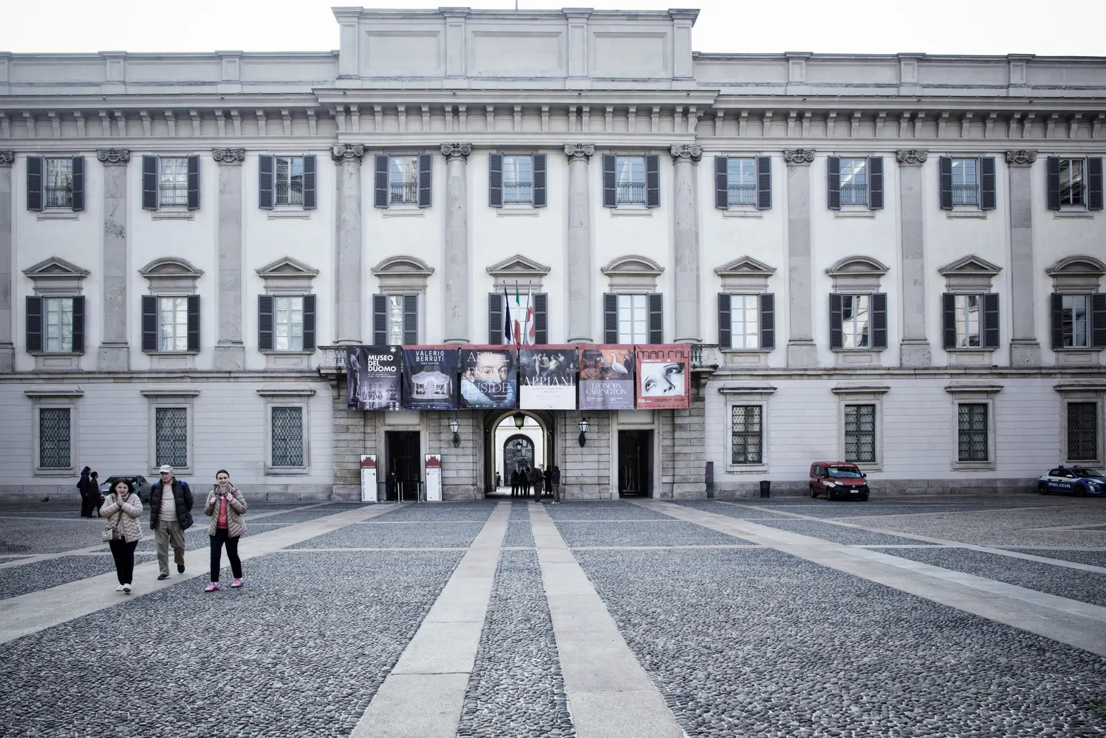 Fotograf macht Porträt von Frau auf der Piazza vor Arkadenfassade